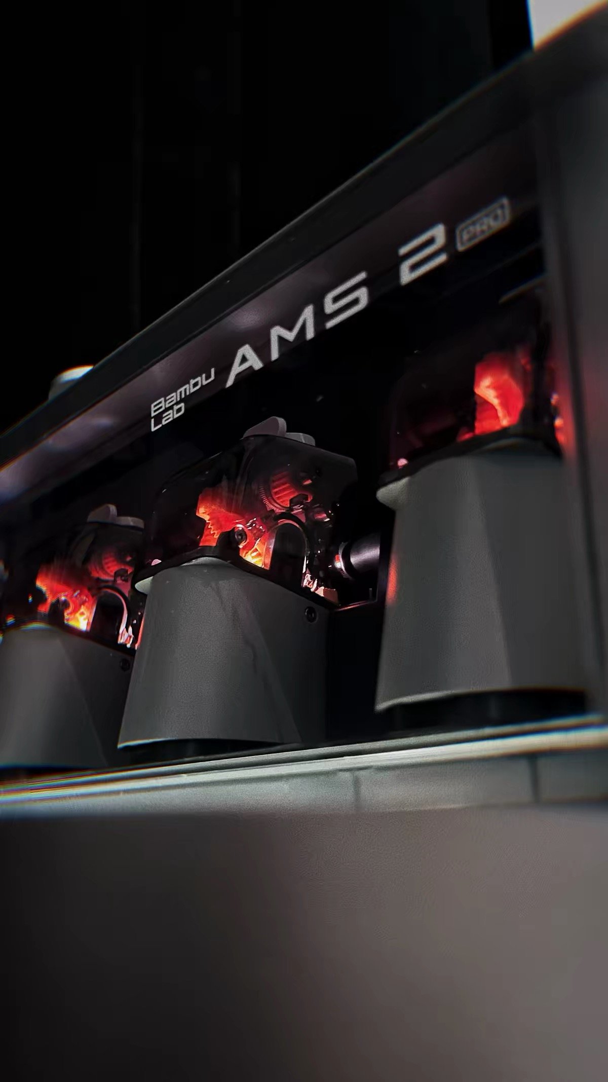 Bambu Lab X2D vs Creality K2 Pro: Which One Should You Buy? (2026) 16 Bambu Lab AMS 2 Pro filament feed mechanism with dramatic red illumination