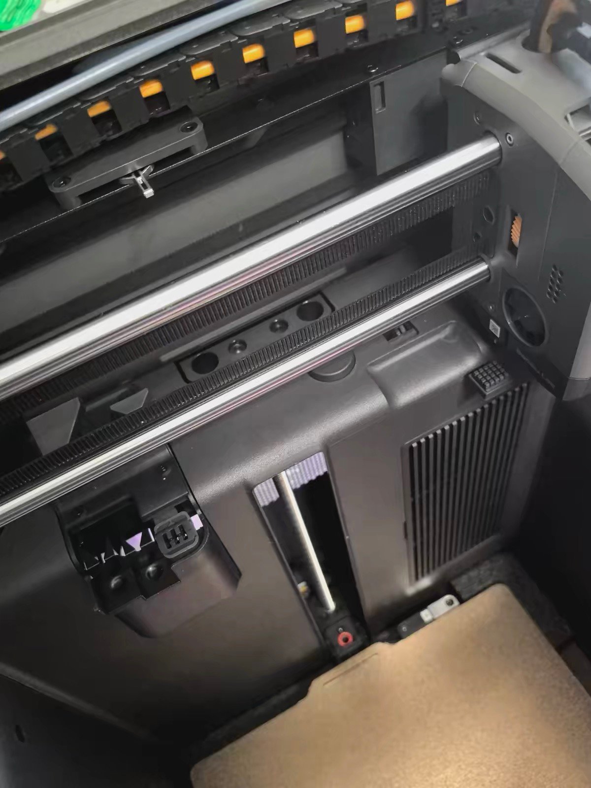 Bambu Lab X2D interior showing X-axis rail system and purge mechanism