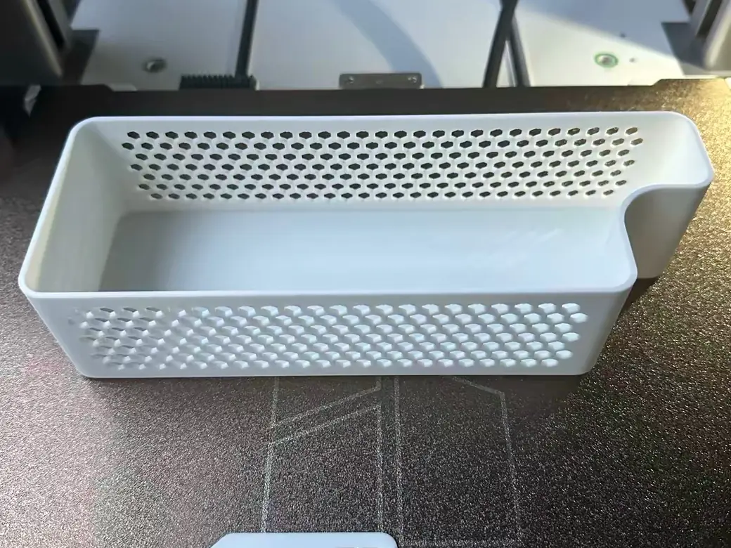 Bambu Lab A2L Review: Is the Big Bed Slinger Worth It? (2026) 13 A white 3D printed storage basket and spool hook printed on the Bambu Lab A2L