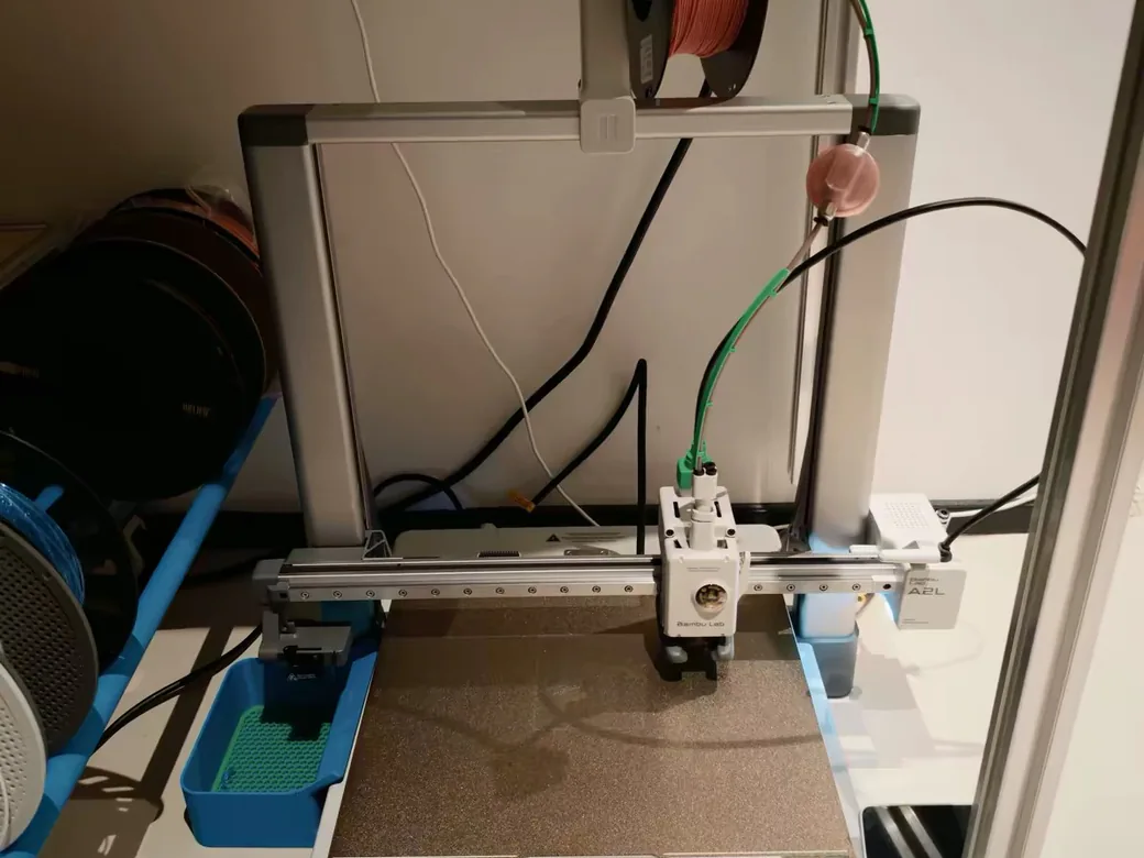 Bambu Lab A2L: Confirmed Specs, Price, and Cutting Module (+ A2 Background) 7 Bambu Lab A2L set up in a home cabinet with a filament spool mounted on top