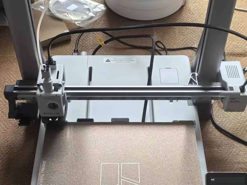 Bambu Lab A2L vs A1 (2026): Bigger, Smarter, and One Catch — Which Should You Buy? 2 Bambu Lab A2L set up at home with a filament drying box and spool on top