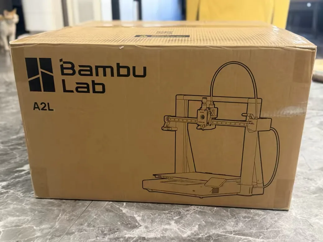 Bambu Lab A2L Review: Is the Big Bed Slinger Worth It? (2026) 3 Bambu Lab A2L shipping box with brand logo and a line drawing of the printer
