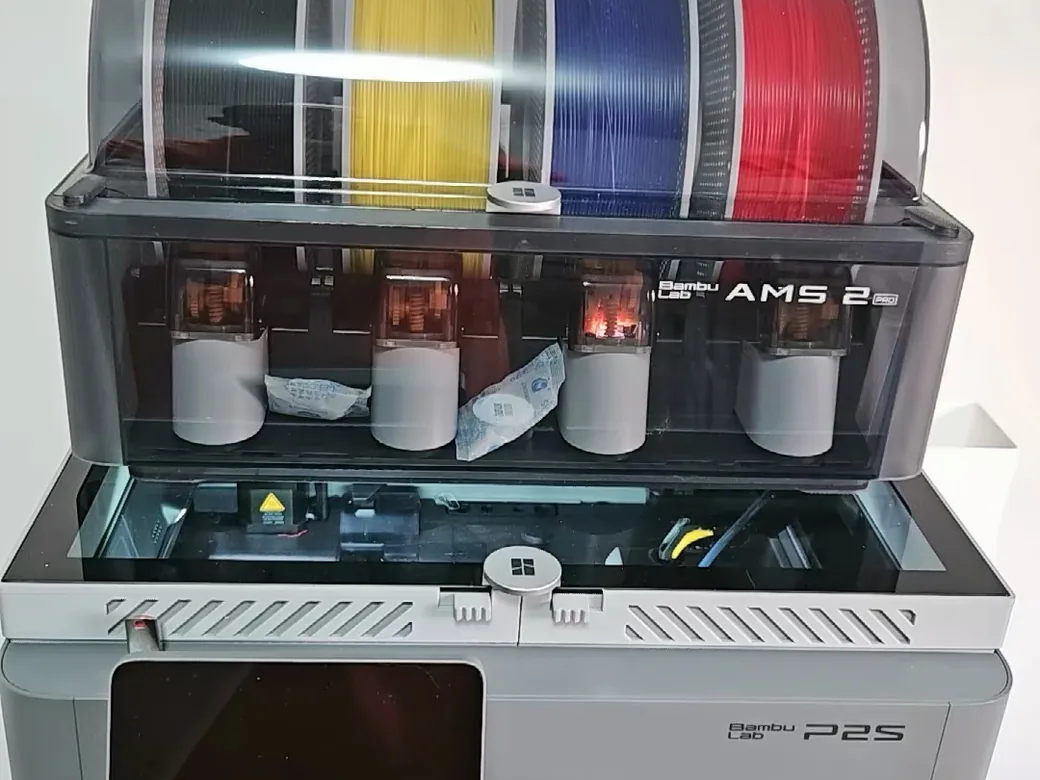 Bambu Lab's official AMS 2 Pro loaded with four colored spools on top of a P2S printer