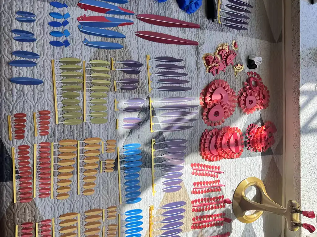 A large batch of multicolor 3D-printed parts in many filament colors drying on a mat
