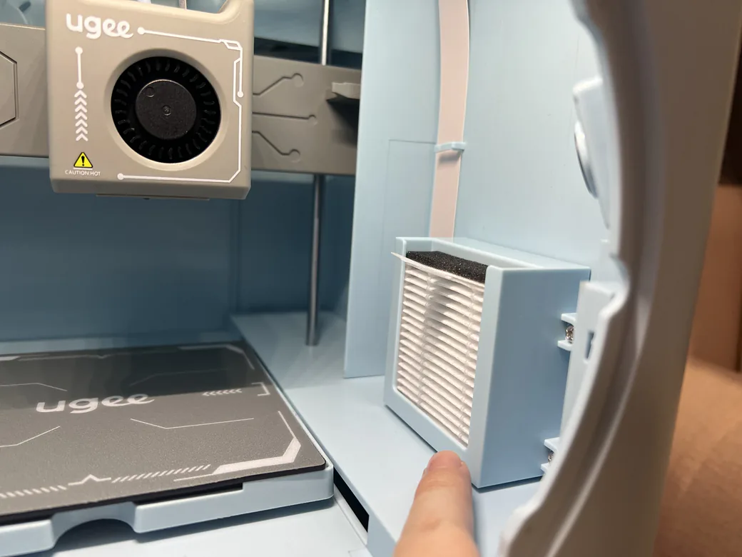 Is 3D Printing Safe for Kids? A Parent's Honest Guide (2026) 3 Hand pulling a HEPA and activated carbon filter cartridge out of an enclosed 3D printer