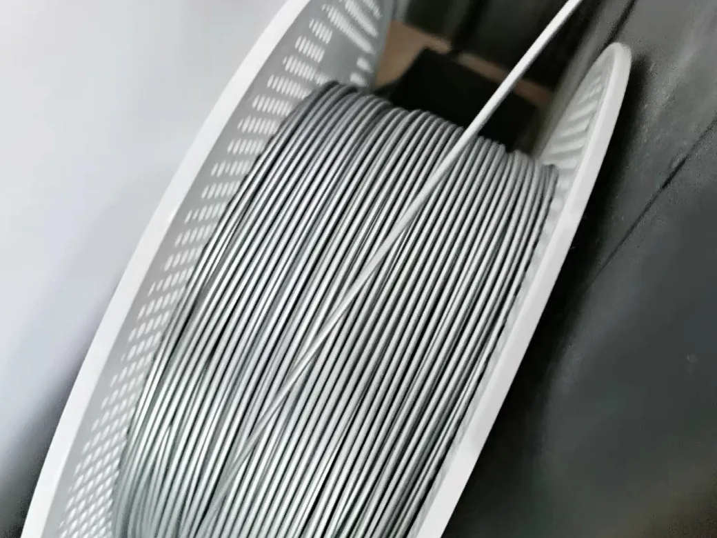 How Many Grams of Filament Are in a Roll? (Net Weight, Spool Sizes & Real-World Yield) 3 Partially used grey 3D printing filament spool showing the level of remaining wound filament