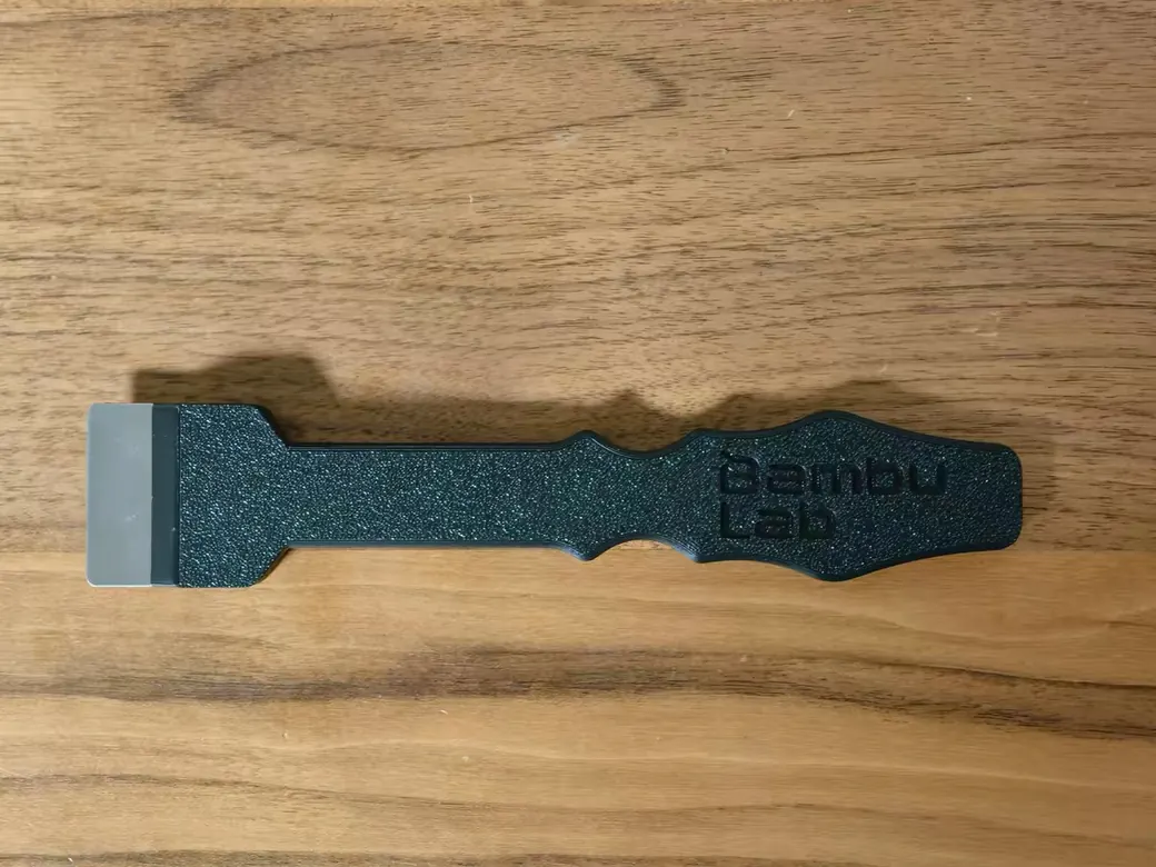 Bambu Lab scraper tool on a wooden desk