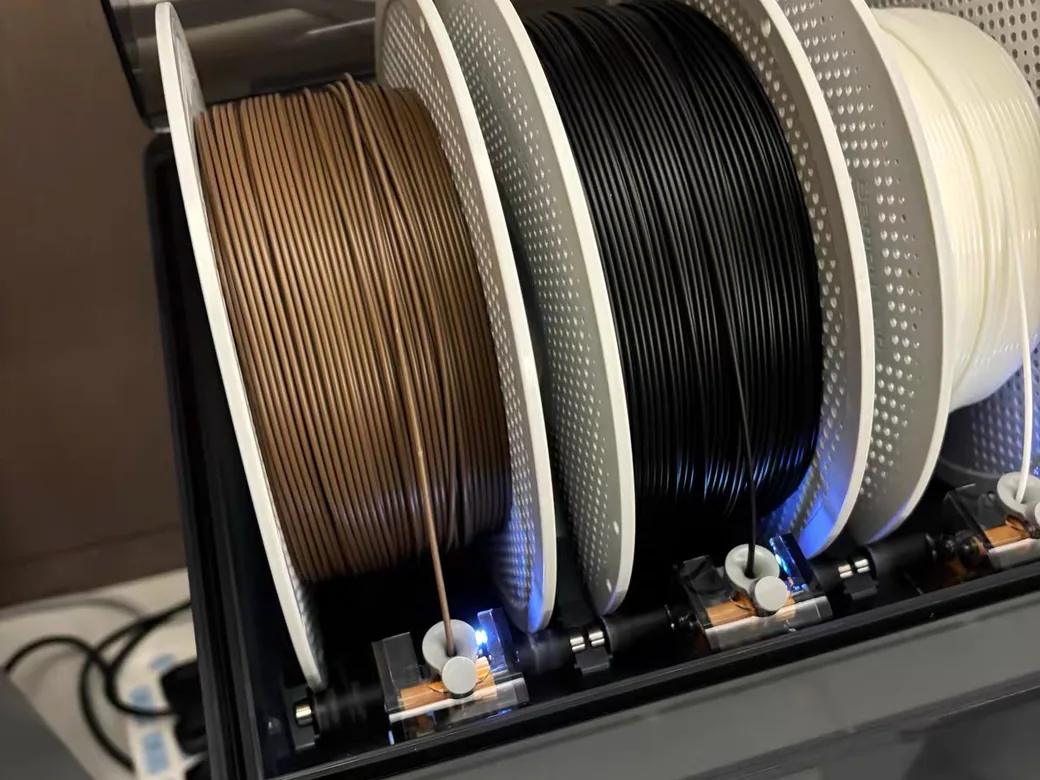 How to Dry Filament Without a Dryer 6 Three filament spools stored inside a sealed dry box with roller mounts