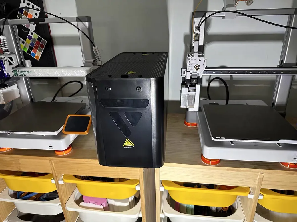 SUNLU S4 Filament Dryer Review: A 4-Spool Workhorse With One Rule You Can't Ignore 7 SUNLU S4 filament dryer seen from the side, standing between two Bambu Lab printers on a workbench