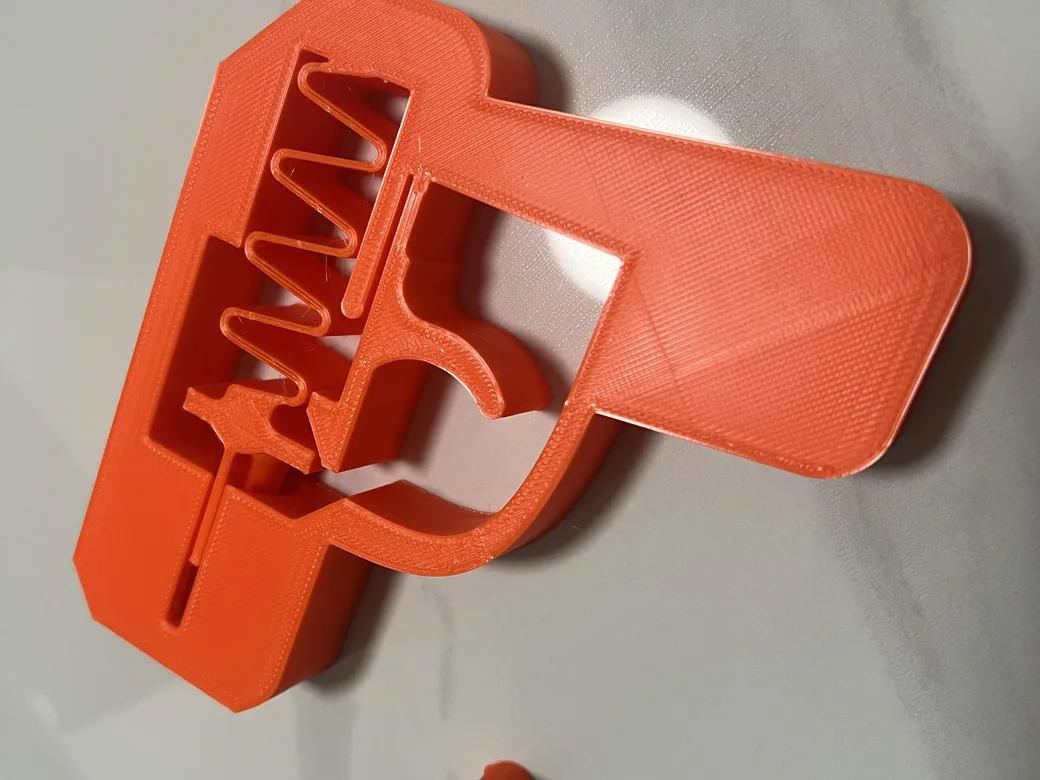 ugee Funbox 3D Printer Review: I Gave It to a 6-Year-Old for a Week 16 Orange 3D printed toy spring launcher with printed-in-place springs, made on the ugee Funbox with Creality PLA