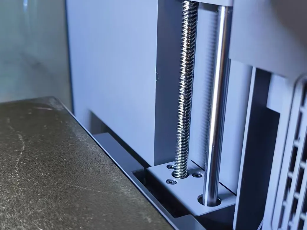 How to Change Layer Height at a Specific Z in Cura (And What to Do Instead) 2 Z-axis lead screw and guide rod beside the build plate inside a 3D printer