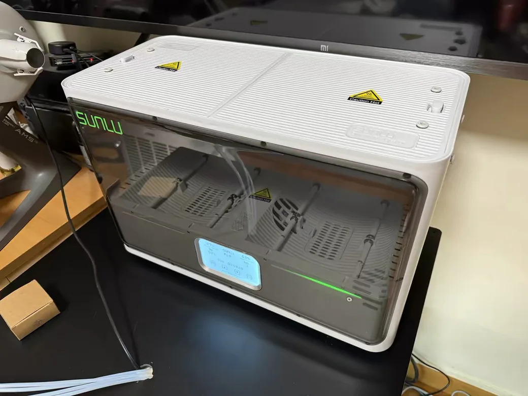 SUNLU FilaDryer S4 running on a desk, LCD showing the drying preset and chamber humidity