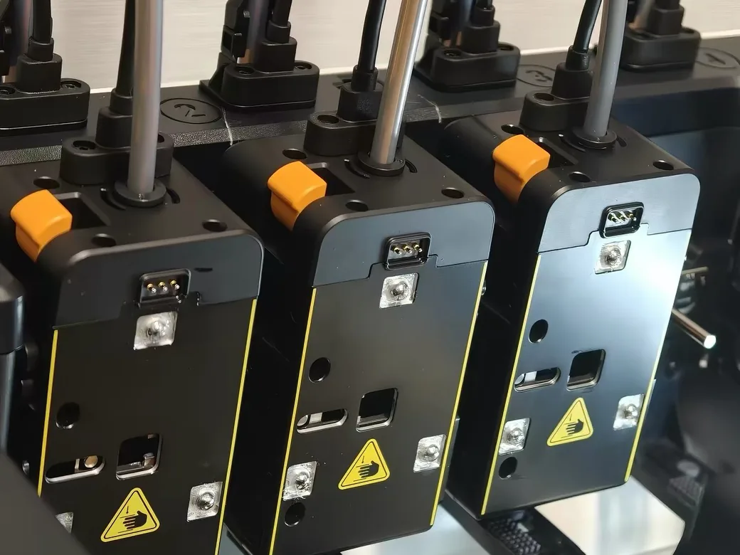 Close-up of the Snapmaker U1's four independent toolheads with orange release levers and PTFE feed tubes
