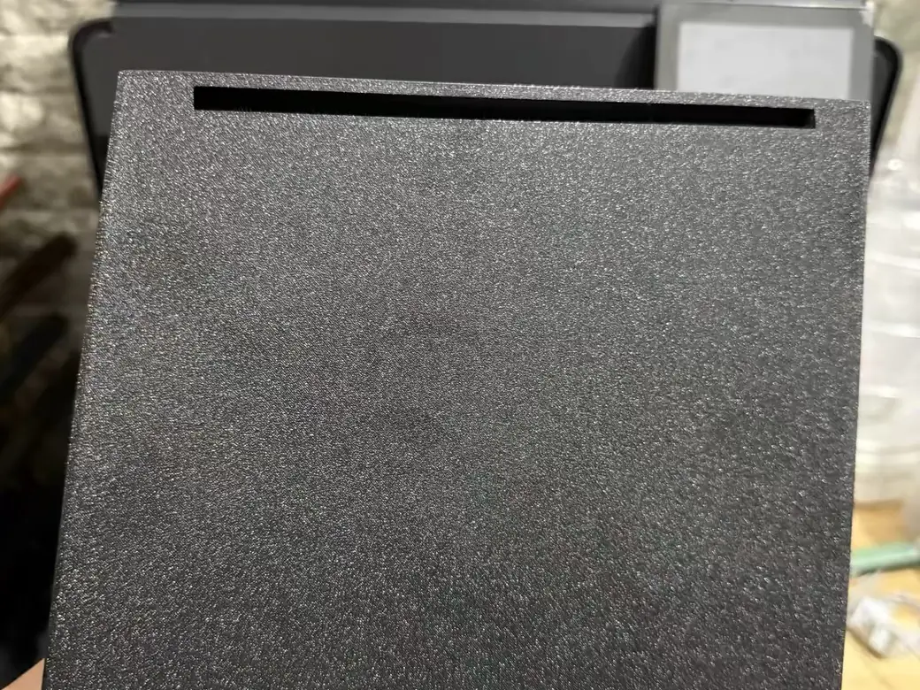 The Best Anycubic Kobra S1 Max Upgrades Worth Buying (2026) 7 A textured black PEI print plate for the Anycubic Kobra S1 Max, held up in front of the printer