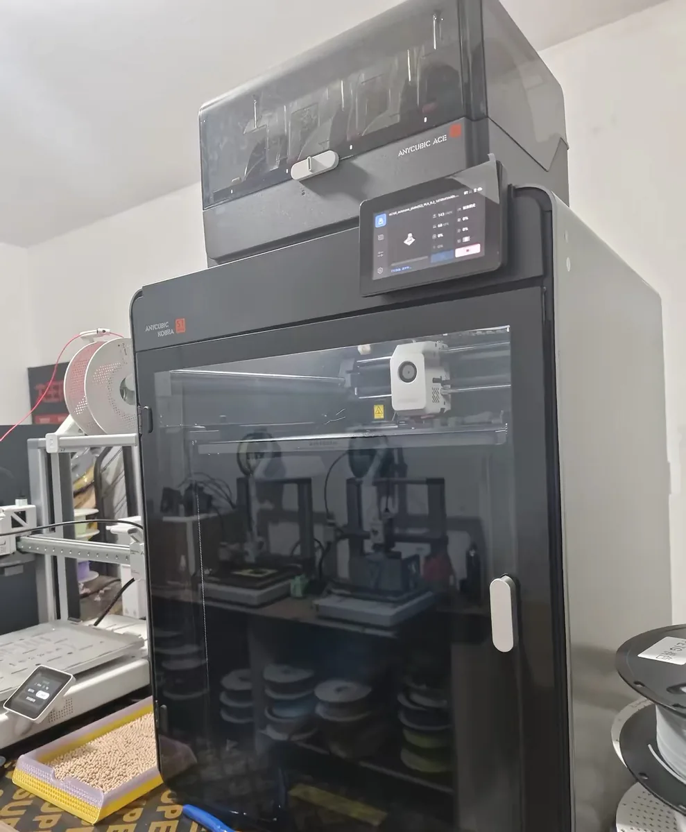 The Anycubic Kobra S1 Max with its ACE multi-material unit mounted on top, standing in a workshop next to filament storage