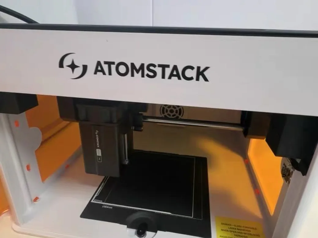 How to Choose the Best Laser Engraver/Cutter for ANY Budget 5 AtomStack P1 enclosed laser engraver front view showing its orange safety enclosure and dual 455nm/1064nm laser module
