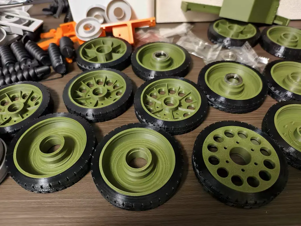 Snapmaker U1 vs Bambu Lab P2S (2026): Toolchanger Speed vs Enclosed Reliability 9 Batch of green and black tank road wheels printed on the Bambu Lab P2S, showing flat top surfaces