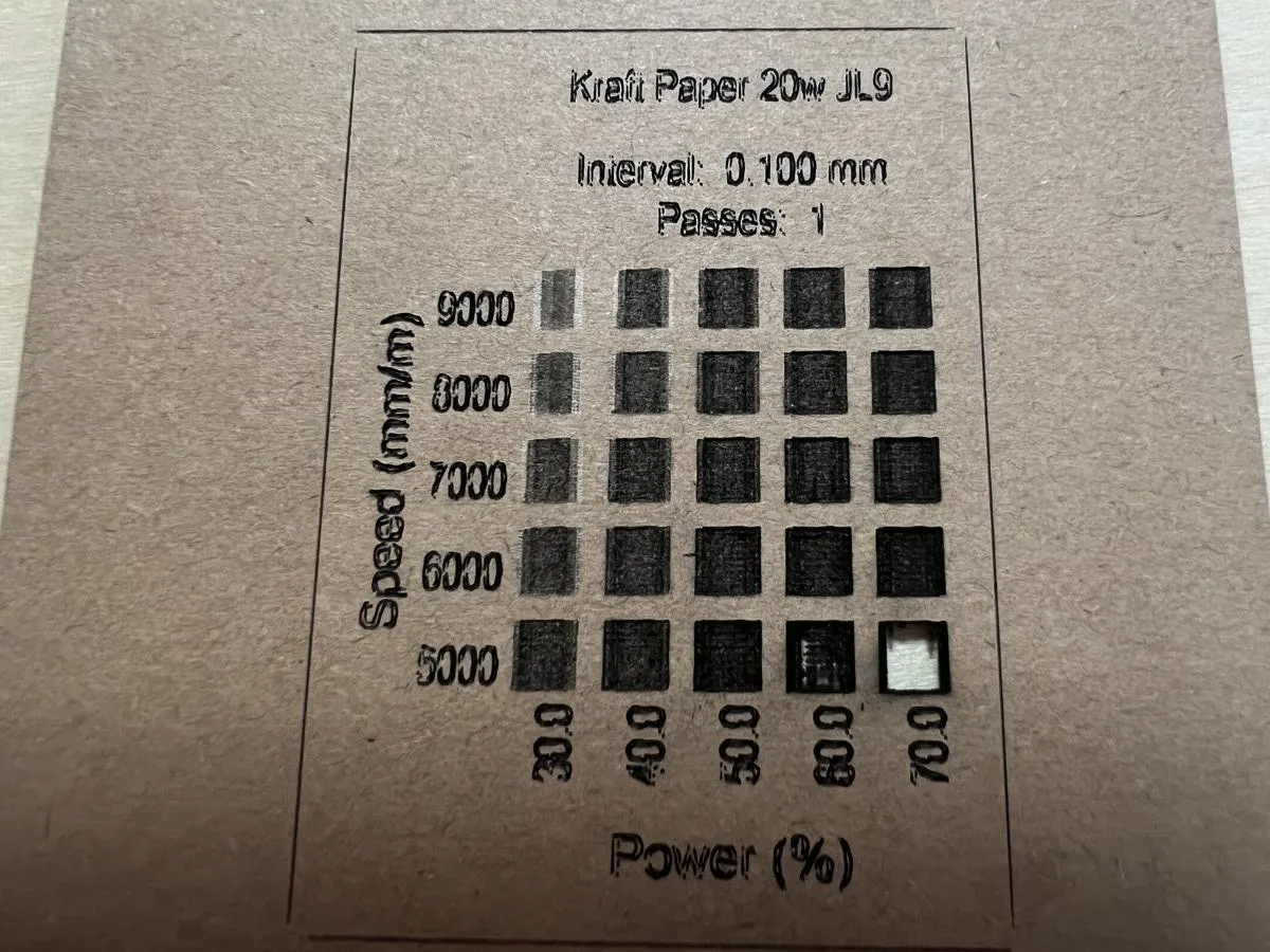Carverall X1Pro (JL9) Review: Unboxing and Cutting Tests (2026) 28 Carverall X1Pro material test grid on kraft paper, with the 70 percent power, 5000 mm per minute cell cut all the way through