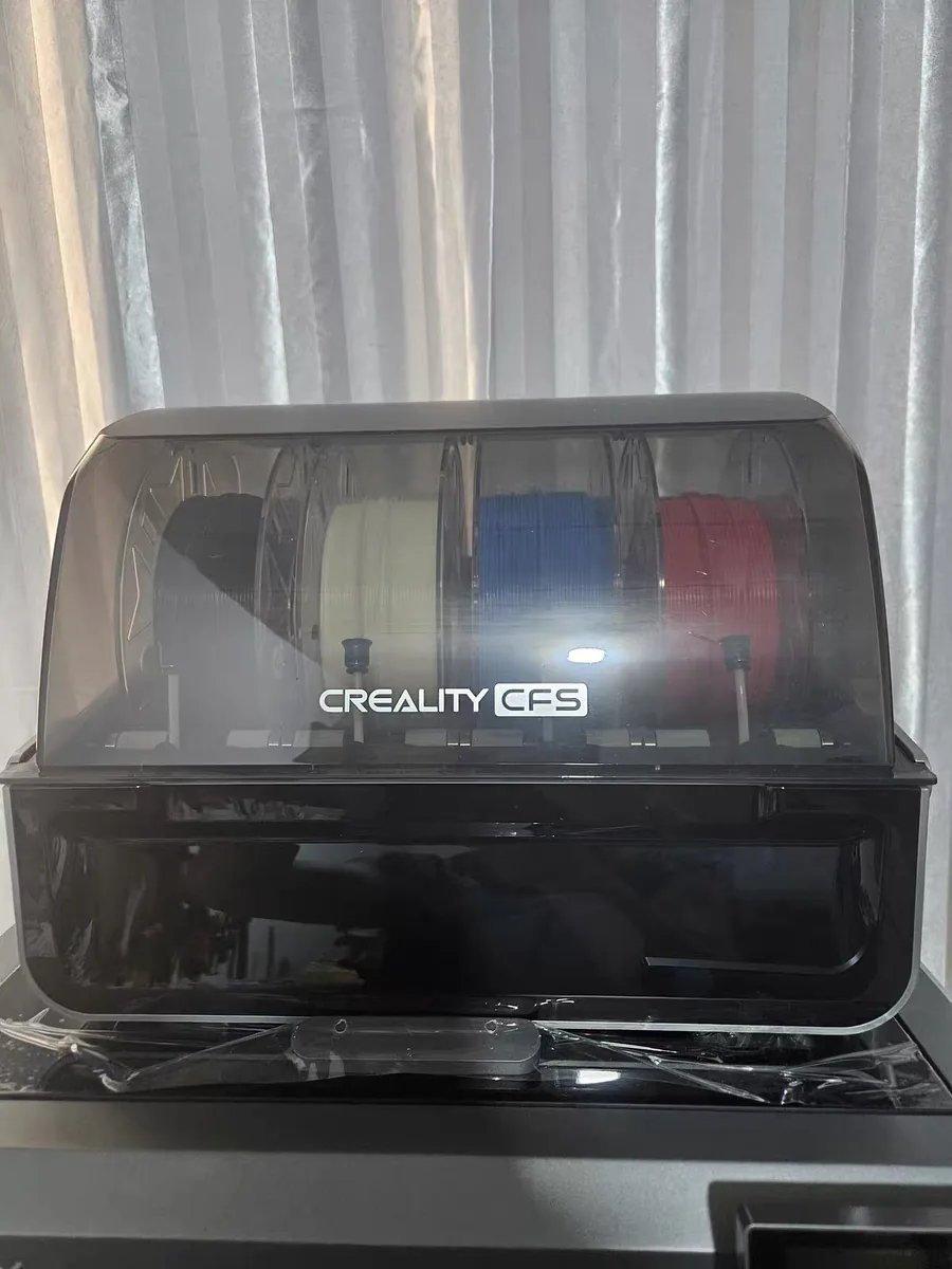 Anycubic Kobra S1 Max vs Creality K2 Plus: Same Promises, Different Failure Modes 10 The Creality CFS multi-material unit with white, red and blue filament spools under its clear lid