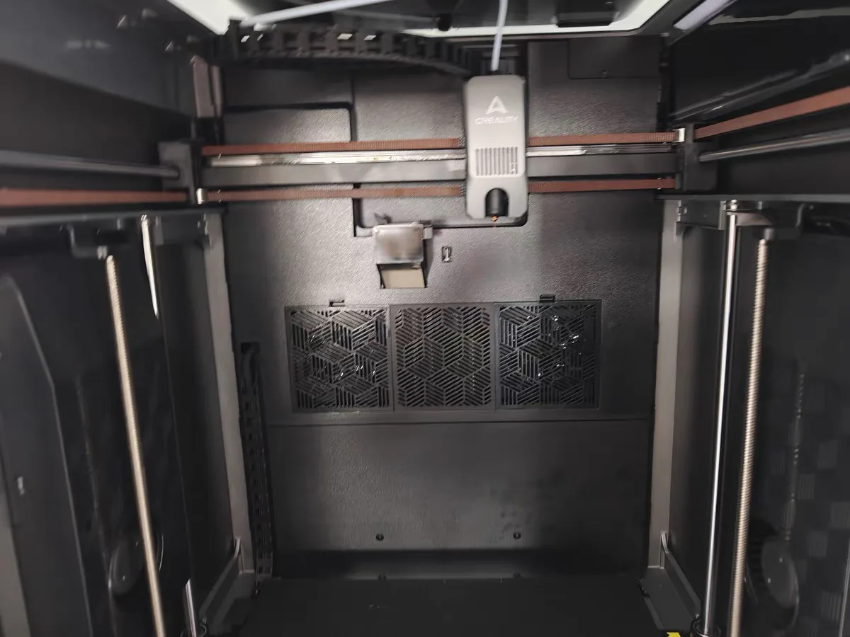 Anycubic Kobra S1 Max vs Creality K2 Plus: Same Promises, Different Failure Modes 6 Inside the Creality K2 Plus chamber: the Creality-branded tool head on its belts, with the chamber filter grilles below