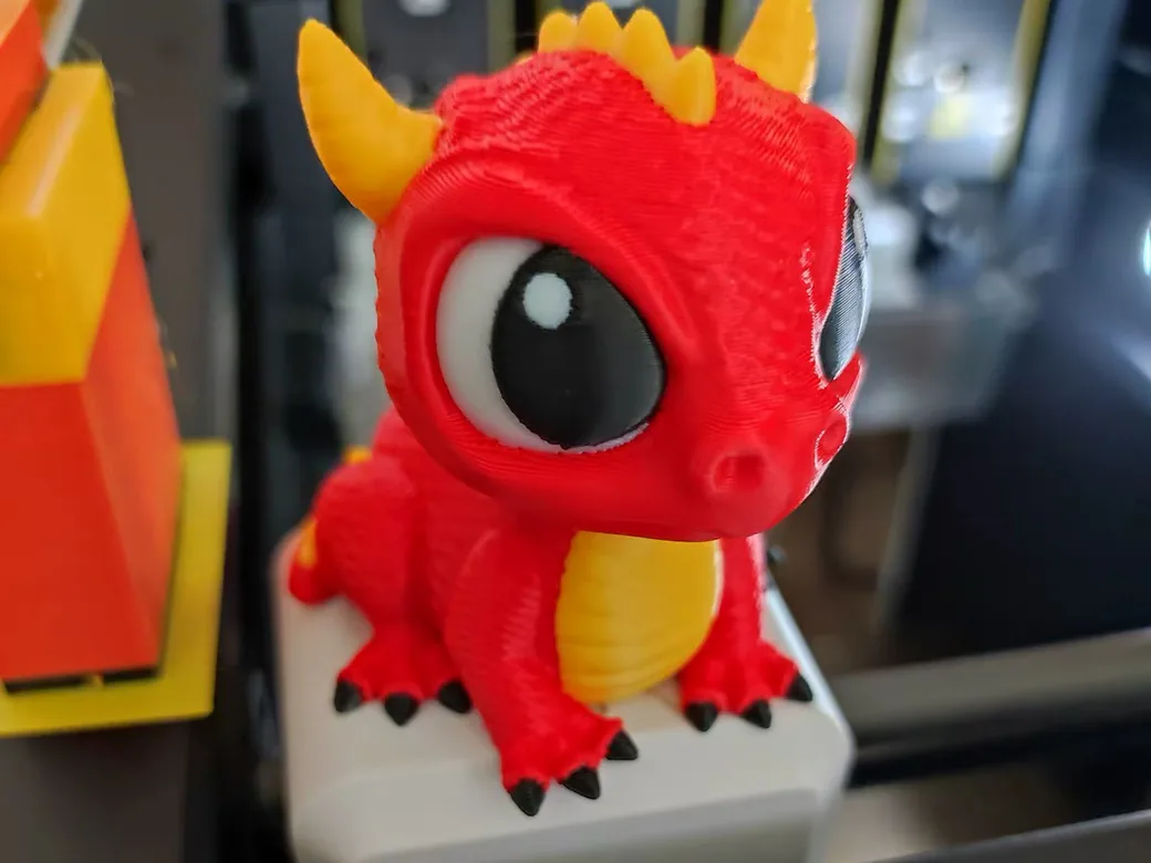 Snapmaker U1 vs Bambu Lab P2S (2026): Toolchanger Speed vs Enclosed Reliability 10 Red, yellow, black and white dragon model printed on the Snapmaker U1, sitting in front of the toolhead dock