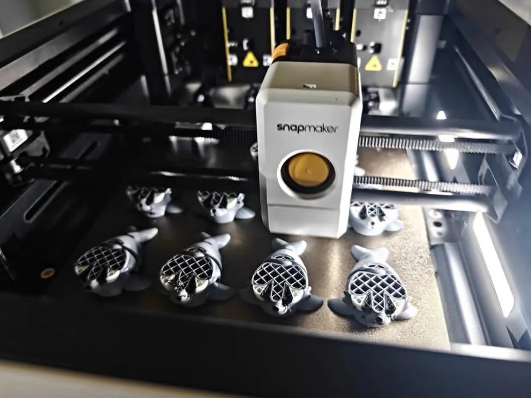 Snapmaker U1 vs Bambu Lab P2S (2026): Toolchanger Speed vs Enclosed Reliability 8 Snapmaker U1 toolhead printing a plate of grey and black two-color turtle models