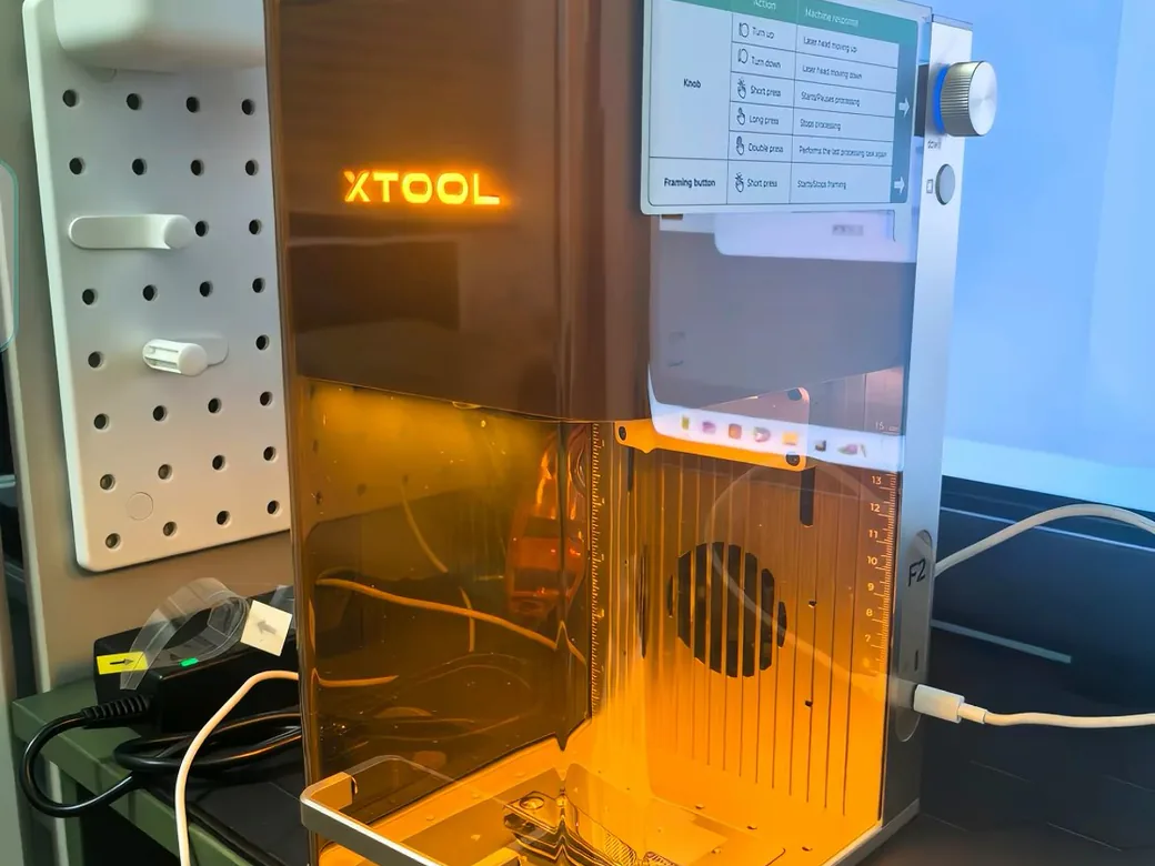 xTool F2 engraving a metal keyring inside its laser chamber