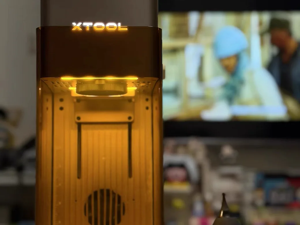 xTool F2 laser glowing amber while running on a desk