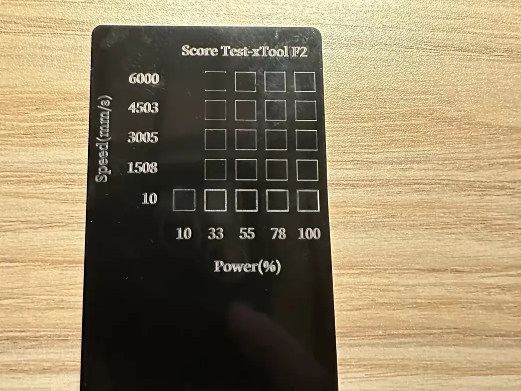 xTool F2 speed and power test grid engraved on a black anodized card