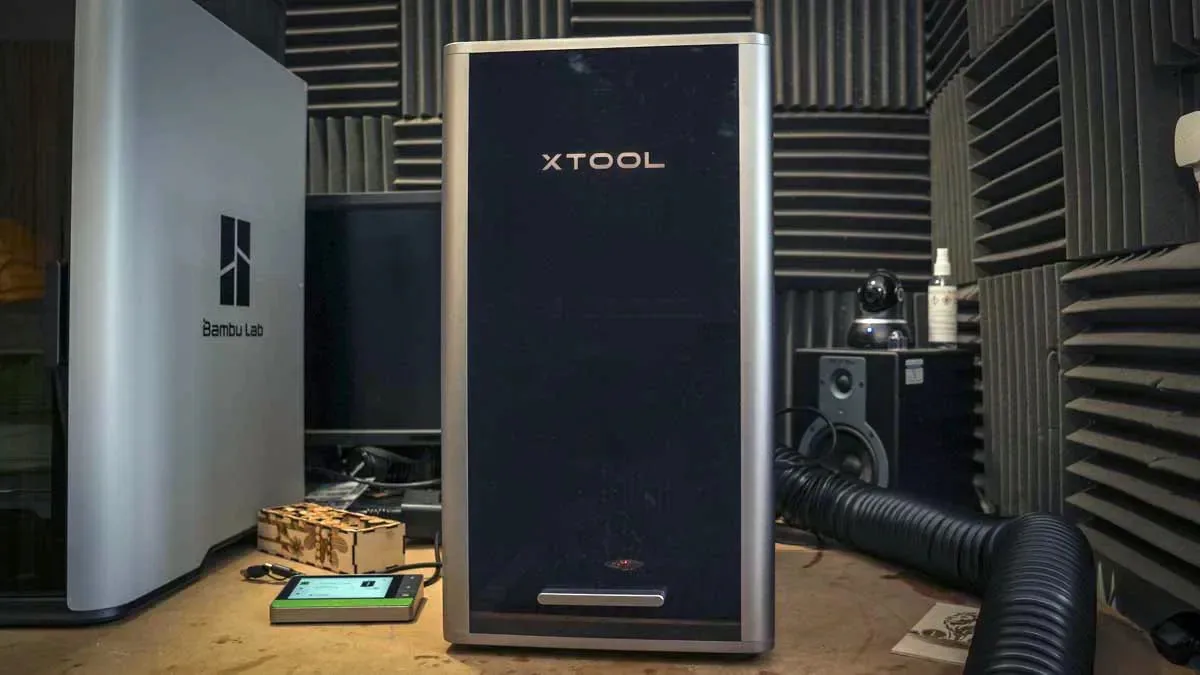 Enclosed xTool F2 Ultra laser workstation with exhaust hose in a workshop