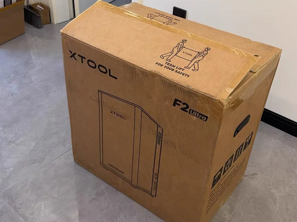 xTool F2 Ultra shipping box printed with a two-person TEAM LIFT FOR YOUR SAFETY warning