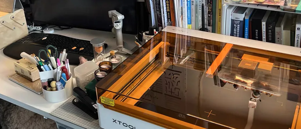 xTool M2 desktop laser on a creative workspace desk, close-up of keyboard and machine