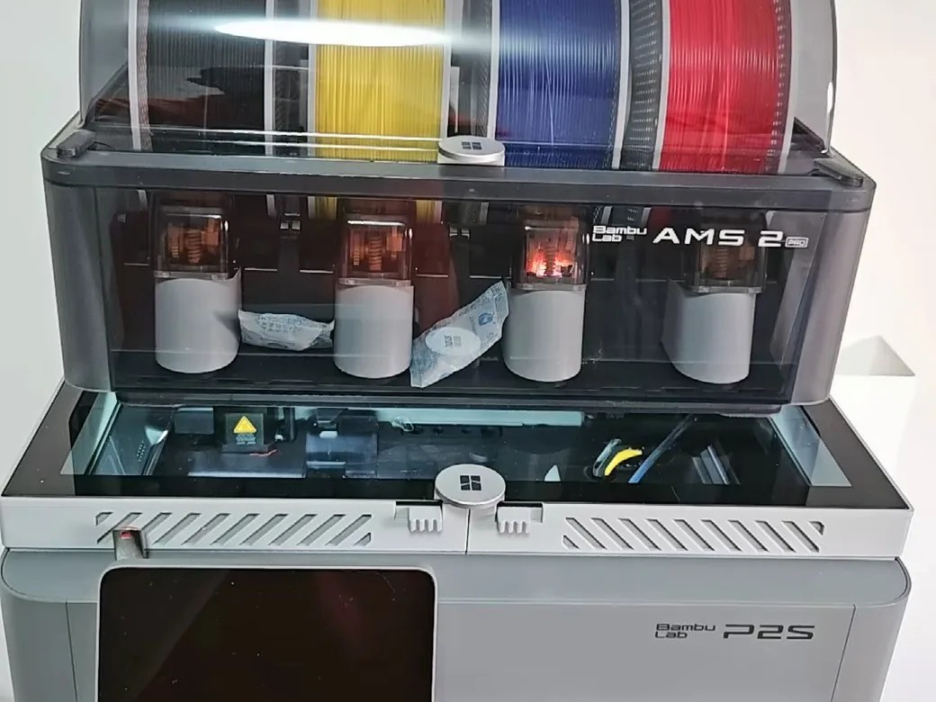 Bambu Lab P2S mit einem AMS 2 Pro, bestückt mit schwarzem, gelbem, blauem und rotem Filament obenauf