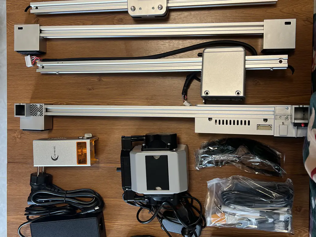 Best Laser Engraver Black Friday Deals 2026: When Sales Start and What to Pay 8 Carverall X1 Pro (JL9) rails, laser module and power supply laid out on a wooden table before assembly