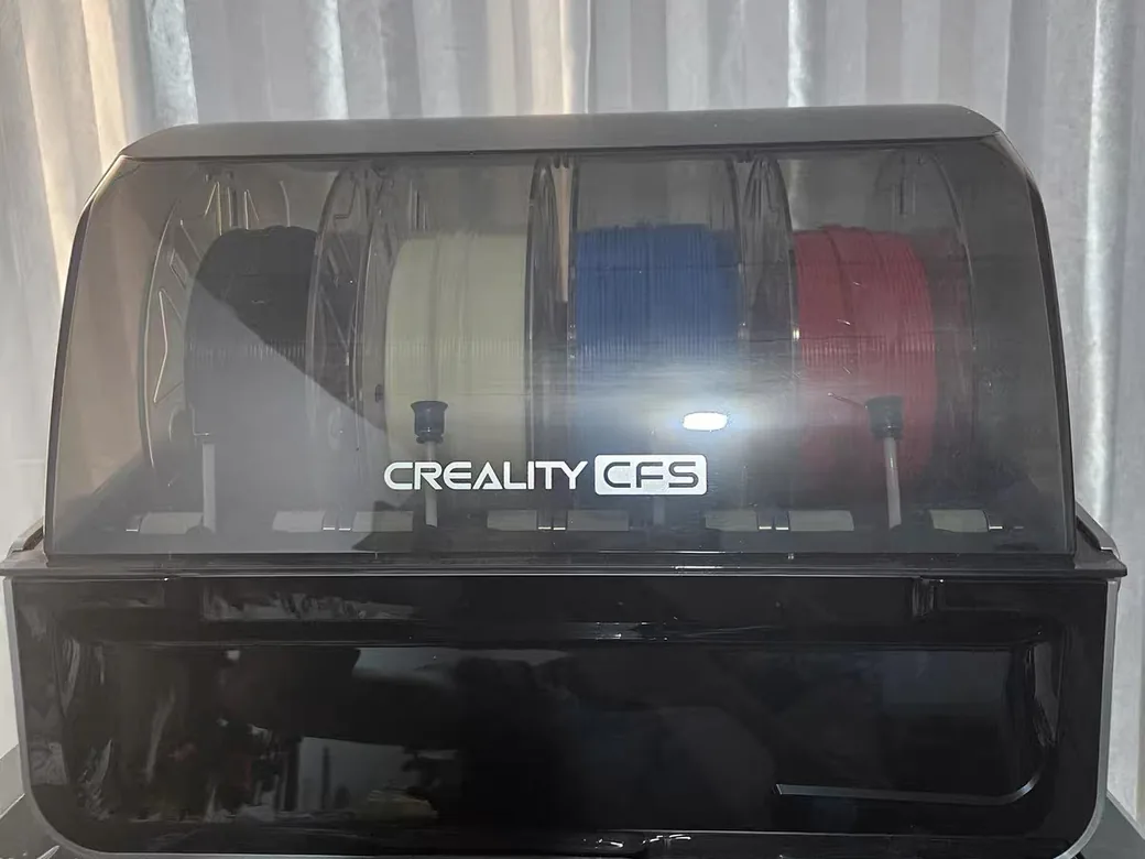Creality K2 Plus vs Bambu Lab P2S (2026): Bigger Heated Box or the Printer That Just Works? 7 Creality CFS unit with black, white, blue and red spools loaded behind its tinted lid