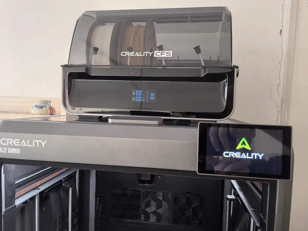 Creality K2 Plus vs Bambu Lab P2S (2026): Bigger Heated Box or the Printer That Just Works? 2 Creality K2 Plus front panel with the K2 Plus badge, CFS unit on top and touchscreen showing the Creality logo