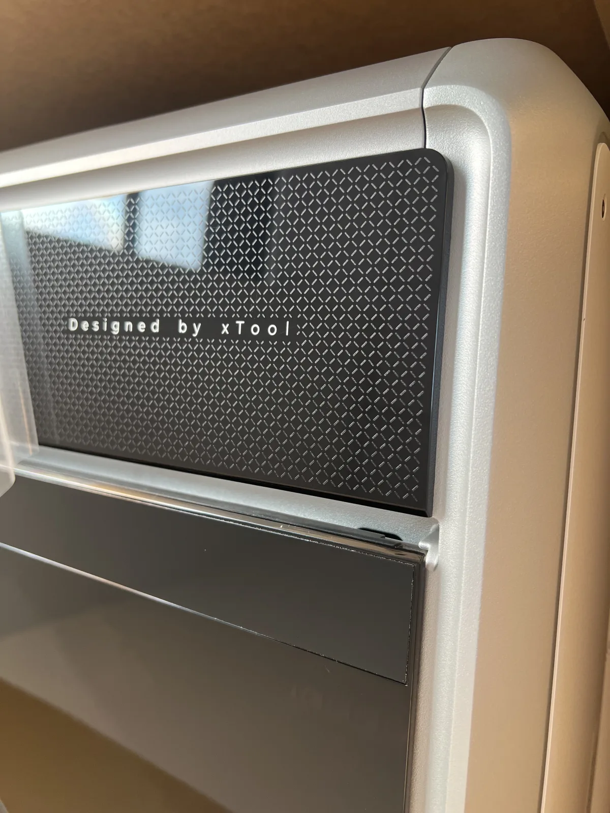 xTool X1 rear glass panel with diamond pattern and Designed by xTool lettering, set in a satin silver aluminum frame